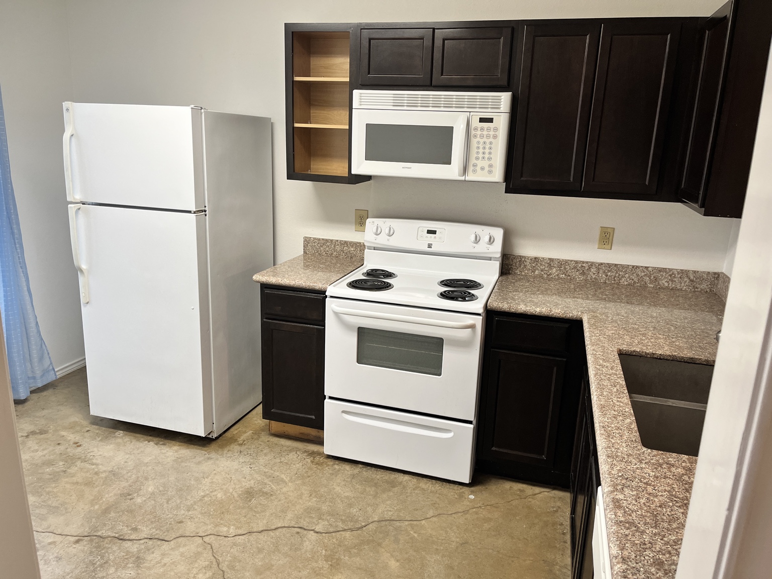 Kitchen with appliances and dark cabinetry